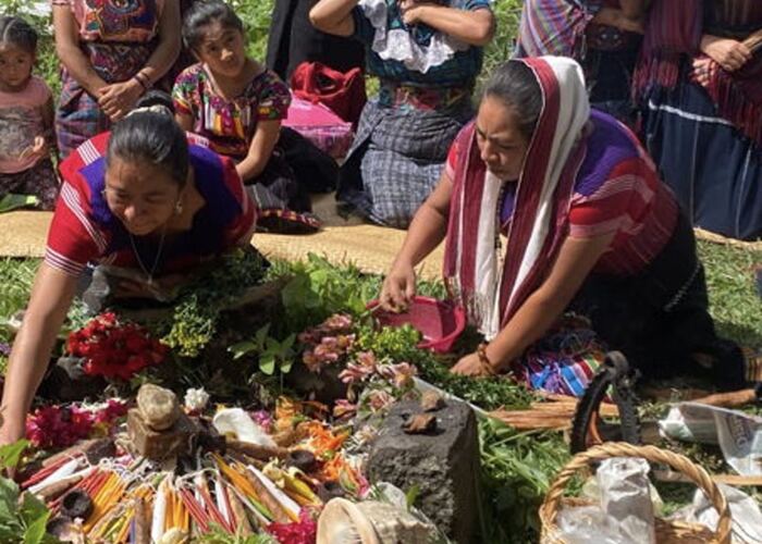 Guatemalan women in ceremony with a flower and herb offering