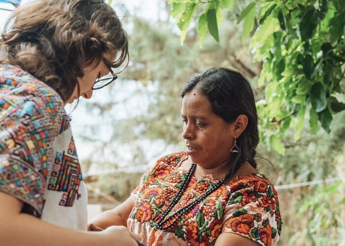 Mariu fitting traditional traje on a Guatemalan abuela