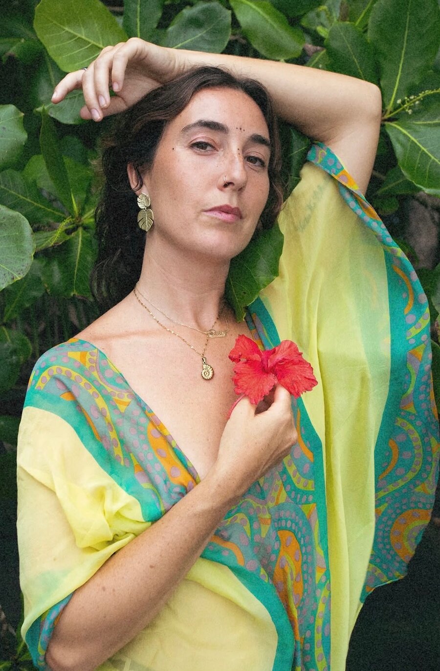 Student holding a hibiscus flower